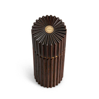 The L'Objet Ionic Salt & Pepper Mill Smoked Oak Set of 2 features dark, ridged cylindrical mills with flower-like tops and gold emblems. Made from European oak, they include a durable metal grinding mechanism and are shown on a white background.