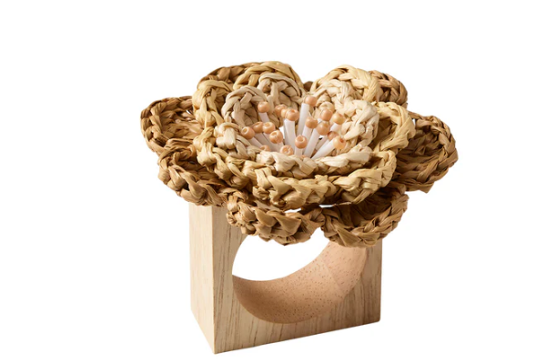 The Kim Seybert Pareo Napkin Ring Set of 4 in natural and brown features light wood rings adorned with raffia-style flowers, highlighted by white and beige beads at the center.