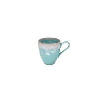 A Taormina Aqua Dinnerware ceramic mug with a turquoise base and a white, dripped-glaze rim.