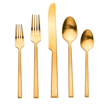 The Ricci Hover Flatware 5 Piece Setting in matte gold features 18/10 stainless steel cutlery—two forks, a knife, a spoon, and a teaspoon—displayed in a row on a white background.
