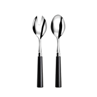 Two Capdeco Marat Wood Flatware salad servers, featuring sleek black handles and crafted from stainless steel, are shown side by side on a white background—one with a slotted fork head, the other with a solid spoon head.
