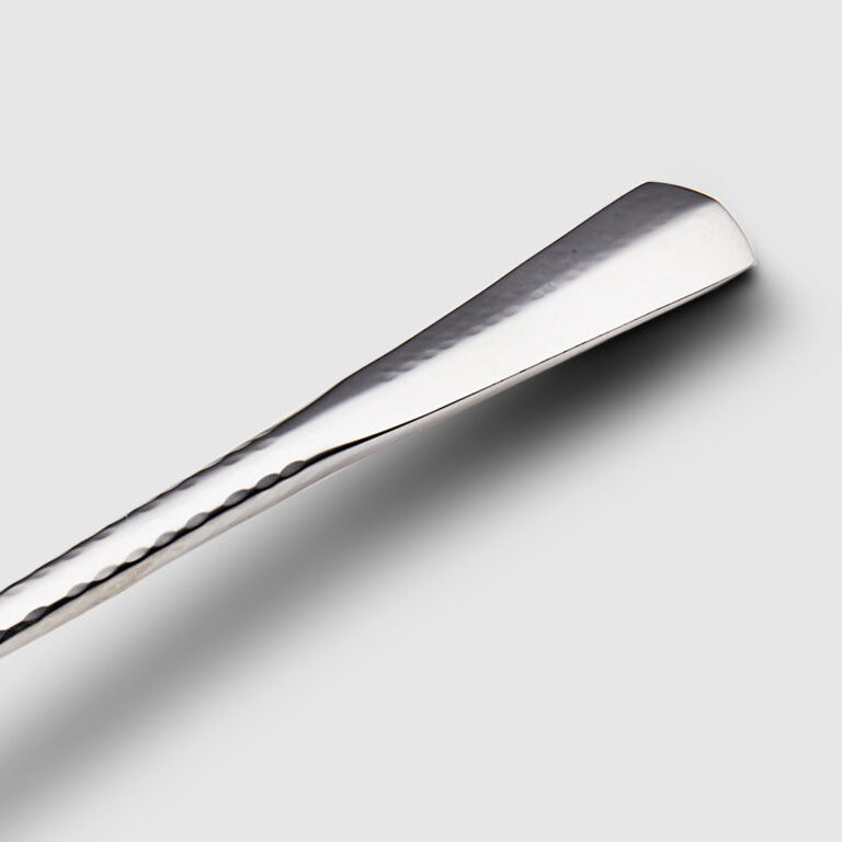 A close-up of the Mary Jurek Alta Deep Garden Vegetable Spoon shows its elegant design and deep bowl, making it a stylish stainless steel addition to your serveware collection, pictured on a light gray background.