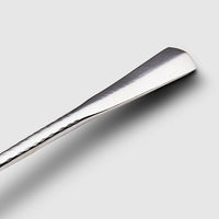 A close-up of the Mary Jurek Alta Deep Garden Vegetable Spoon shows its elegant design and deep bowl, making it a stylish stainless steel addition to your serveware collection, pictured on a light gray background.