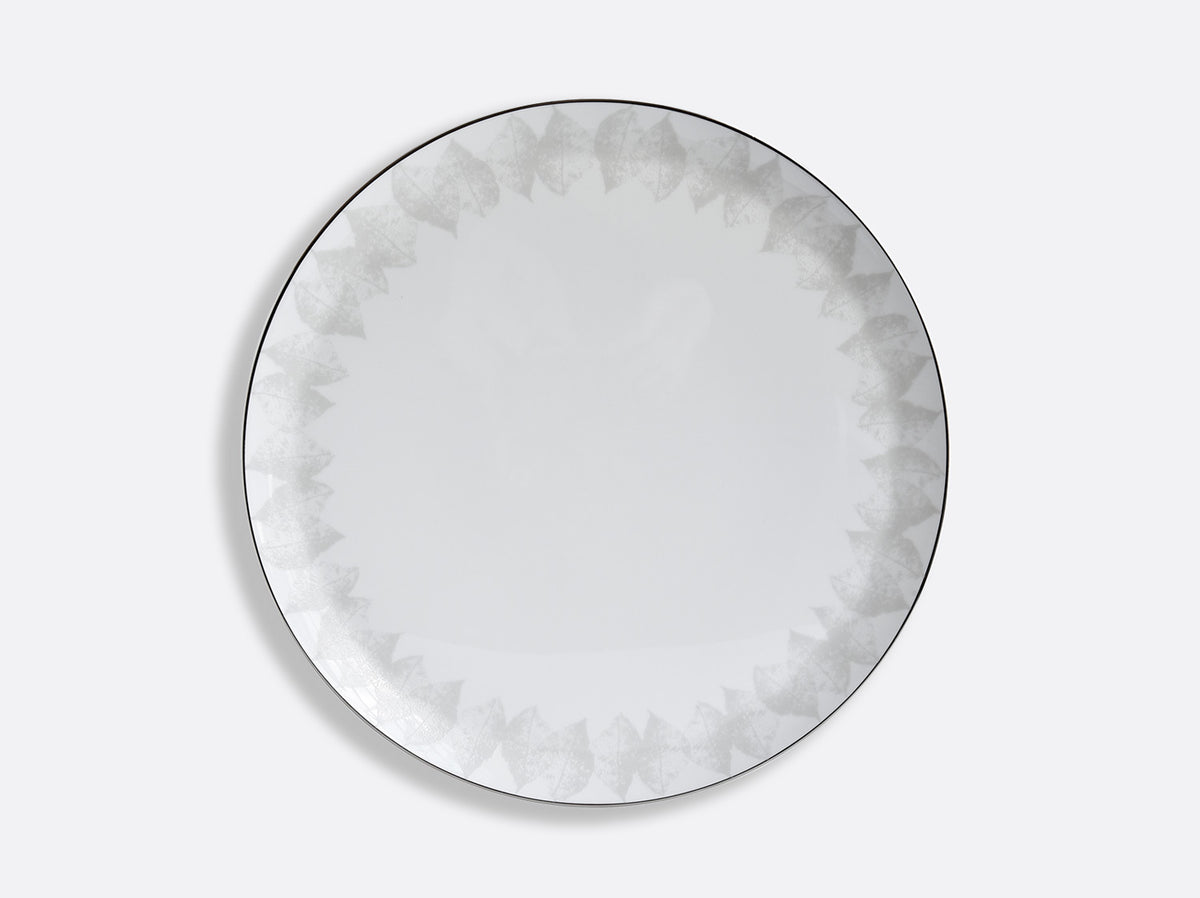 The Bernardaud Silva Dinnerware Serving Piece features a round white plate with a subtle gray geometric pattern and platinum relief on the rim, finished by a thin dark edge—an elegant addition to any table.
