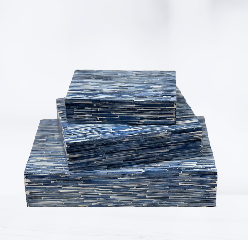Three Blue Tiles Bone Boxes from A Sanoma Inc, featuring a textured deep blue and gray striped pattern, are stacked atop each other against a white background, creating an elegant accent piece inspired by the classic bone box design.