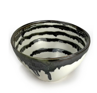 The Michael Wainwright Linea Dip Bowl is a ceramic bowl with a glossy black and white striped design and black glaze drips on the rim and exterior, shown against a plain white background.