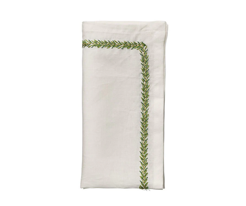 The Jardin Napkin Set of 4 by Kim Seybert features white embroidered linen napkins with green leaf borders forming an L-shaped design—an elegant addition to any table setting.