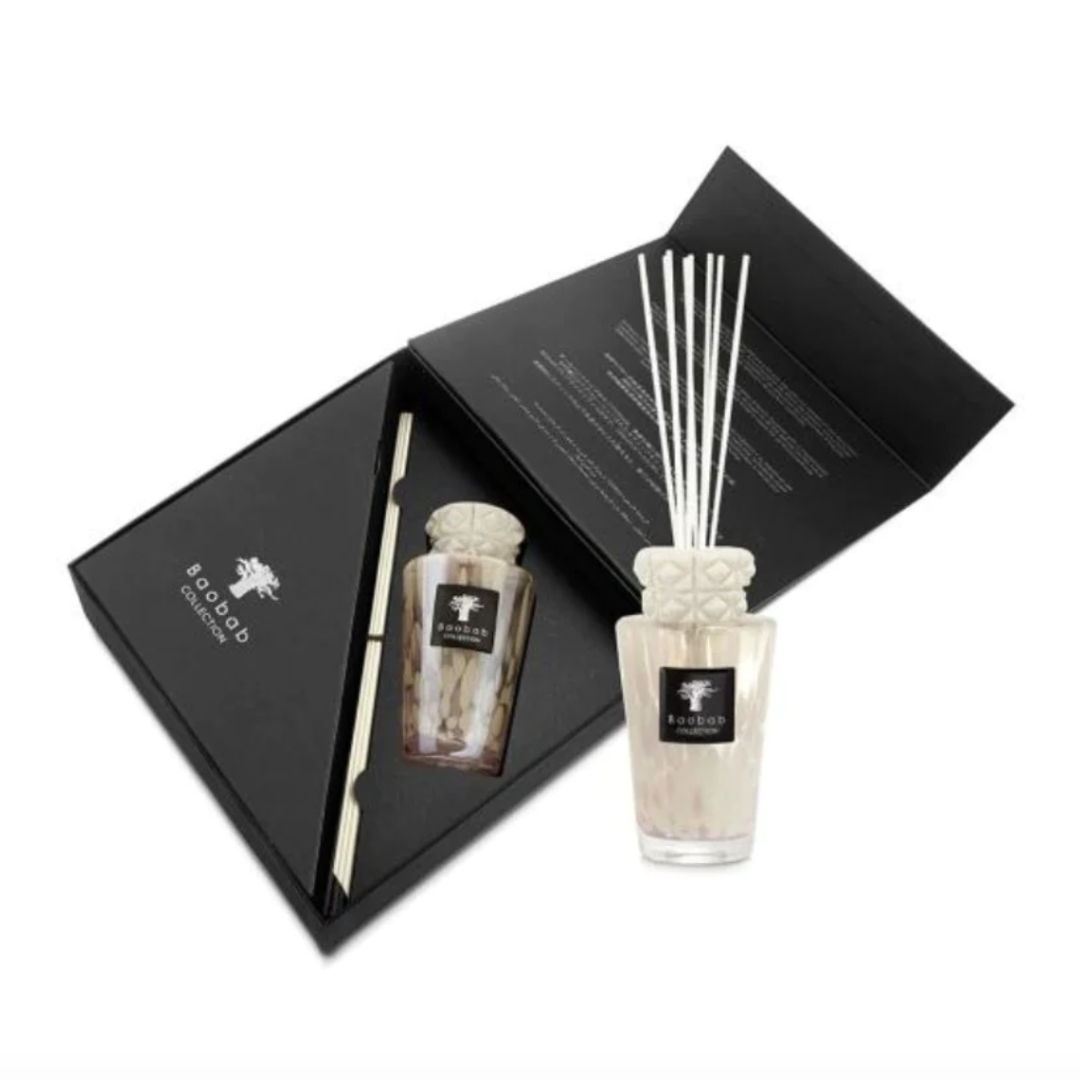 The Baobab Totem Pearls White Diffuser is a luxury home fragrance set with a glass diffuser, white decorative reeds, and elegant black packaging with product details inside the lid.