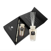 The Baobab Totem Pearls White Diffuser is a luxury home fragrance set with a glass diffuser, white decorative reeds, and elegant black packaging with product details inside the lid.