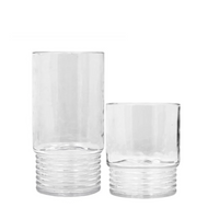 Two Santorini Acrylic Drinkware cups by Le Cadeaux, one tall and one short with ribbed bases and smooth tops, are shown side by side on a plain white background.