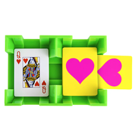 The Canasta Sets Canasta Spinner is a green plastic card holder that holds a Queen of Hearts and two yellow cards with pink hearts—a unique accessory for your next canasta game night.