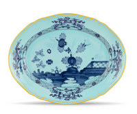 Oval porcelain platter from Ginori 1735’s Oriente Italiano Dinnerware Iris, featuring a turquoise ground, gold rim, blue-and-white chinoiserie floral motif with insects and garden landscape, framed by a latticework border.