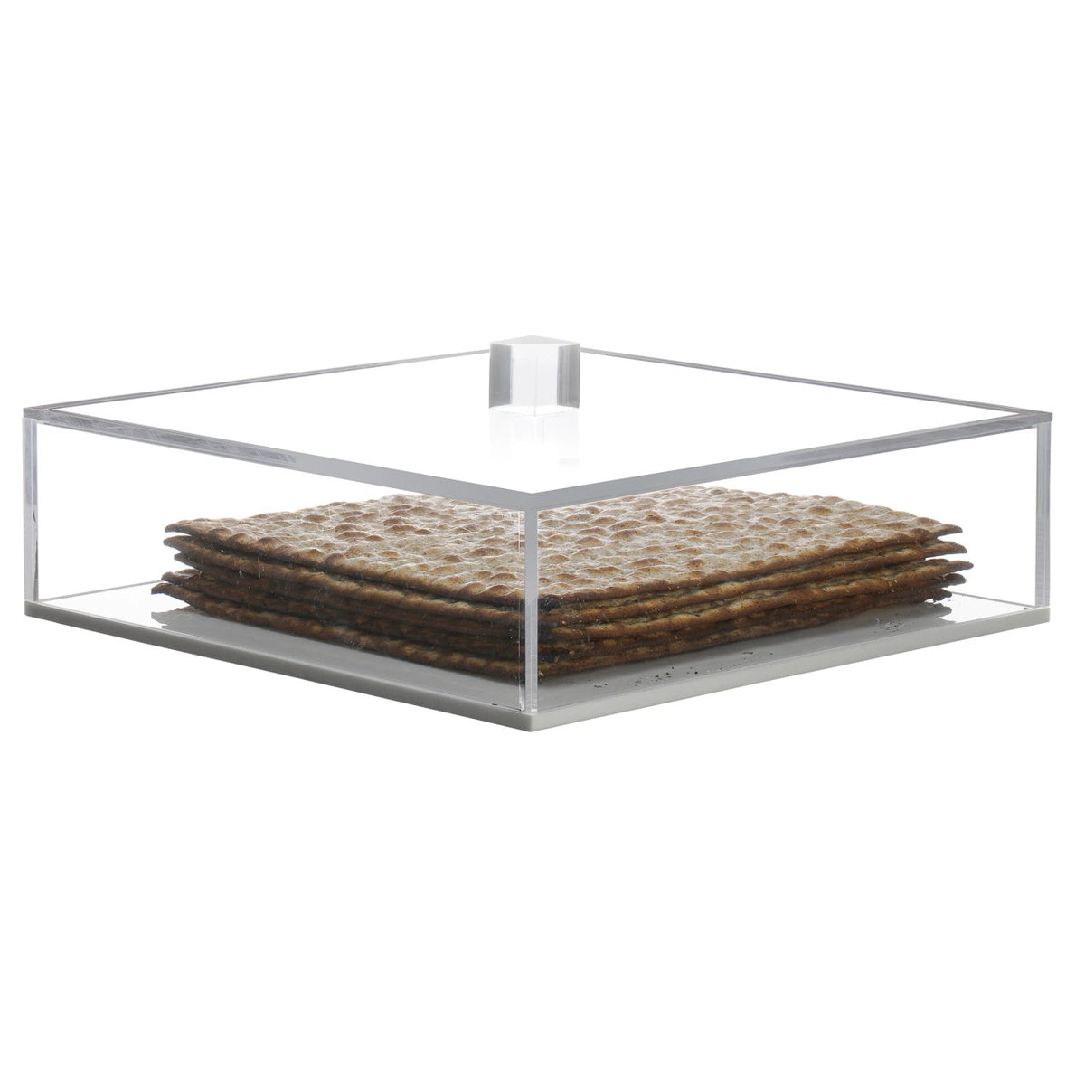 A stack of square matzo crackers is displayed in the BT-Shalom Lucite Matzah Box With Lid, offering a functional storage solution and a stylish decorative touch.