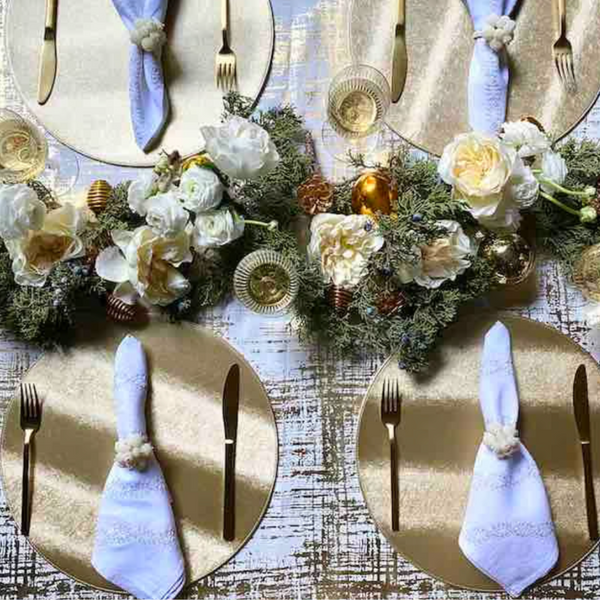 Create an elegant table with Von Gern Home’s Textured Metallic Reversible Placemat Set of 4, paired with gold chargers, white napkins, floral centerpieces, and gold accents for a festive yet easy-care setting.