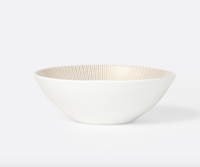 The Bernardaud Sol Dinnerware bowl is crafted from white Limoges porcelain, featuring a gently curved shape and fine vertical gold lines along the inner rim, shown on a plain light background.