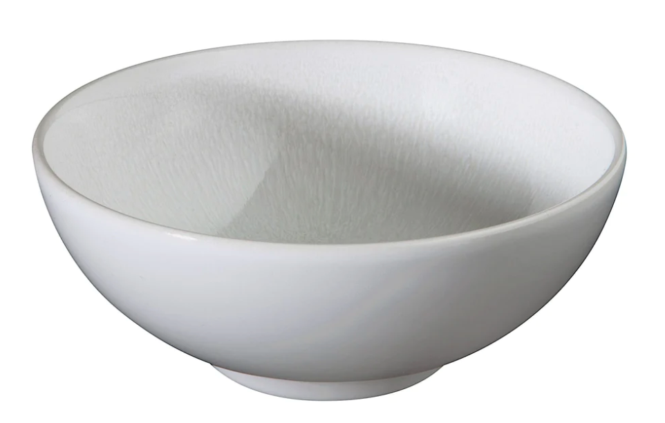 A simple white ceramic bowl with a smooth finish, shown at an angle against a white background, highlights the handmade durability of Jars - Rosenthal Tourron Dinnerware Neige, crafted in France.