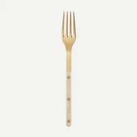 The Sabre Bistro Horn Serving Fork features a shiny gold finish and glossy light ivory handle with three brass rivets, made in France, shown against a plain white background.