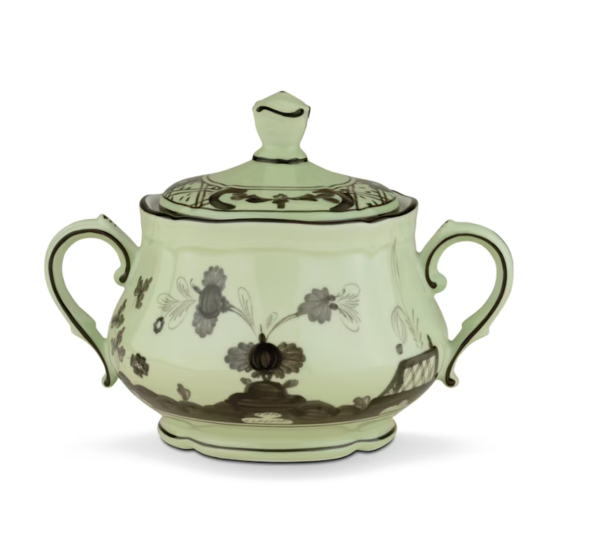 The Oriente Italiano Dinnerware Bario sugar bowl by Ginori 1735 features light green ceramic, two handles, a lid, and dark chinoiserie floral and geometric designs, shown against a white background.