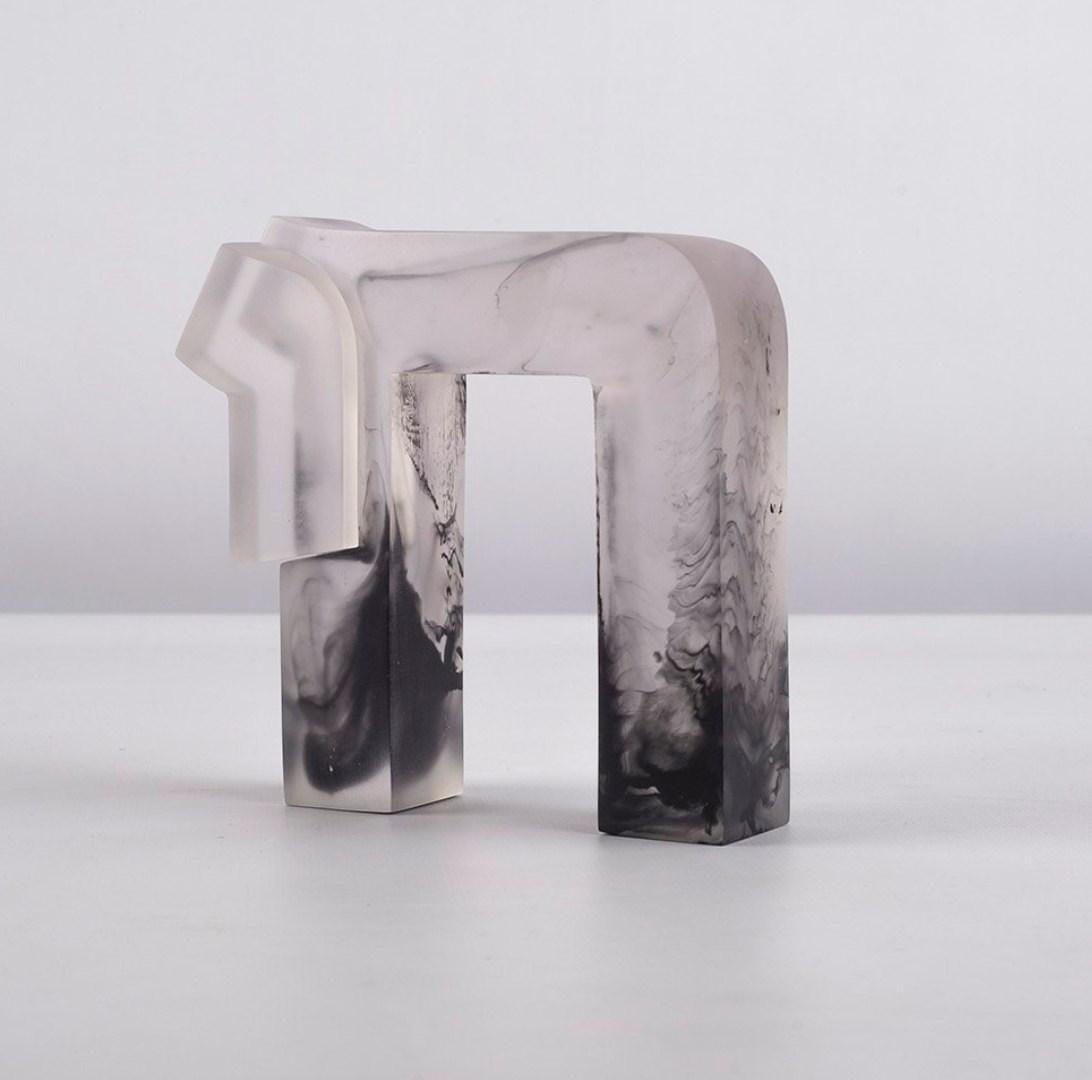 The Chai Sculpture by CDMX / BRUCI is a translucent abstract resin piece with a geometric shape and marbled black and white patterns, displayed on a white surface against a plain background.
