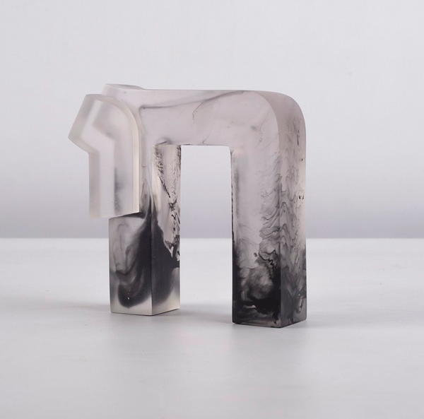 The Chai Sculpture by CDMX / BRUCI is a translucent abstract resin piece with a geometric shape and marbled black and white patterns, displayed on a white surface against a plain background.
