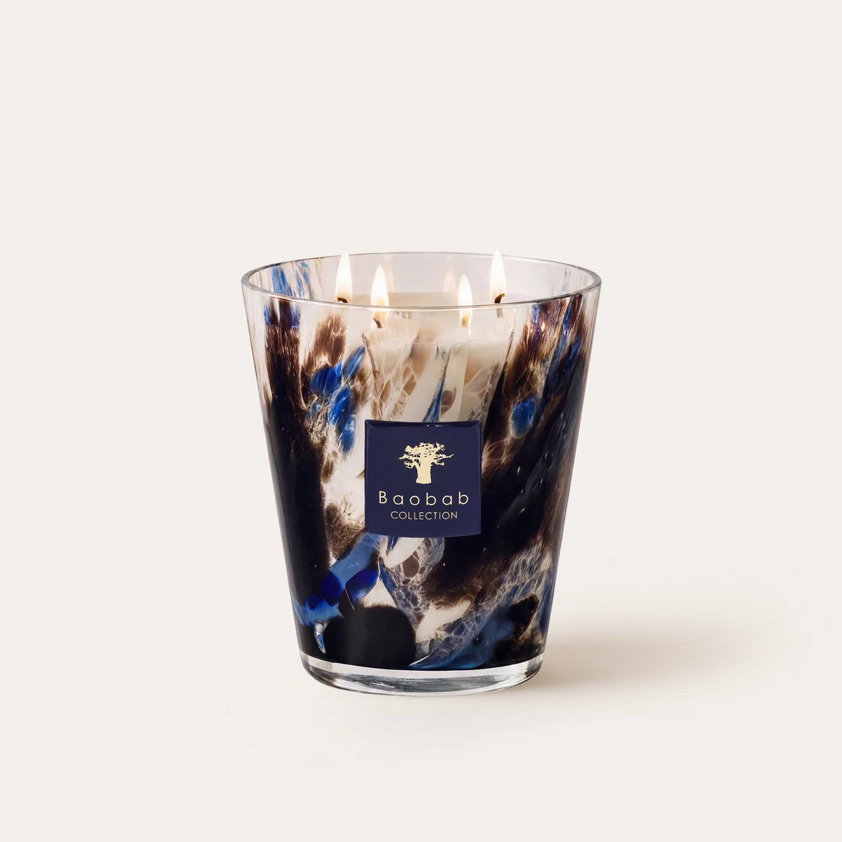 The Baobab Halona Candle Blue World is a hand-blown glass candle with five lit wicks, presented in a decorative holder adorned with blue, black, and white marbled patterns against a plain white background. This distinctive piece fills your space with the sophisticated aroma of rosemary, cedarwood, and vetiver.