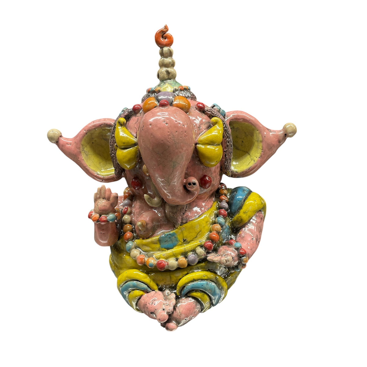 The Currey & Company Golden Fortune Ganesha Sculpture depicts the Hindu deity with large pink ears, yellow and blue attire, and beaded necklaces, seated with a blessing hand—perfect as meditation décor and displayed on a white background.