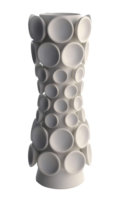 The Cumulus Collection Alabaster by KleinReid is a tall, white handcrafted vase featuring a narrow waist and raised circular discs of various sizes across its surface against a plain white background.