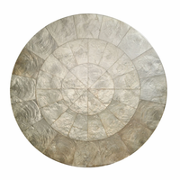 The Capiz Shell Placemat Grey Set of 4 by Kim Seybert features elegant round placemats with a mosaic of silver-gray segments, arranged in concentric rings for a sophisticated look.