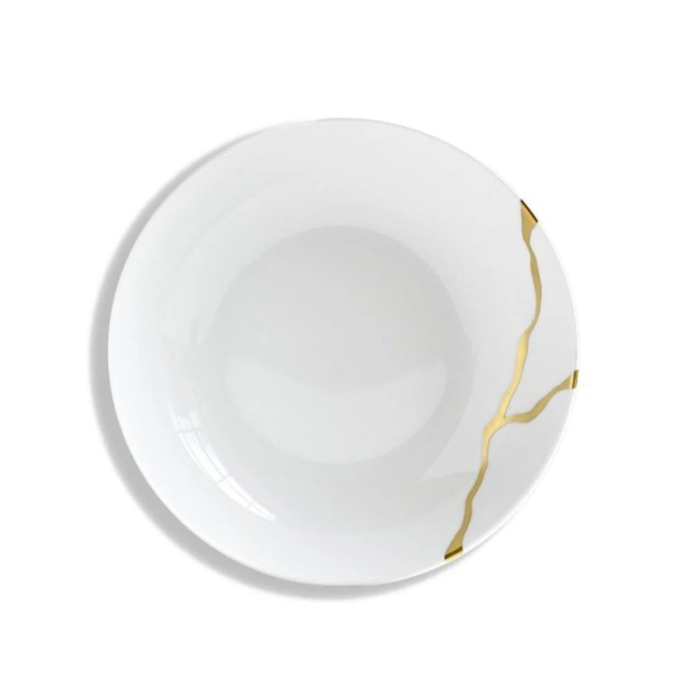 A piece from Bernardaud’s Kintsugi Dinnerware collection, this white ceramic plate features gold lines reminiscent of repaired cracks, drawing inspiration from the Japanese art of Kintsugi, and is displayed against a white background.