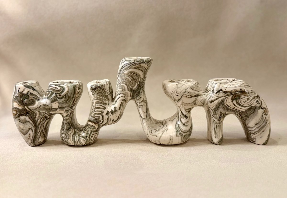 Sela Form Forma Menorah - Marble with an abstract, swirling black, white, and grey sculptural design.