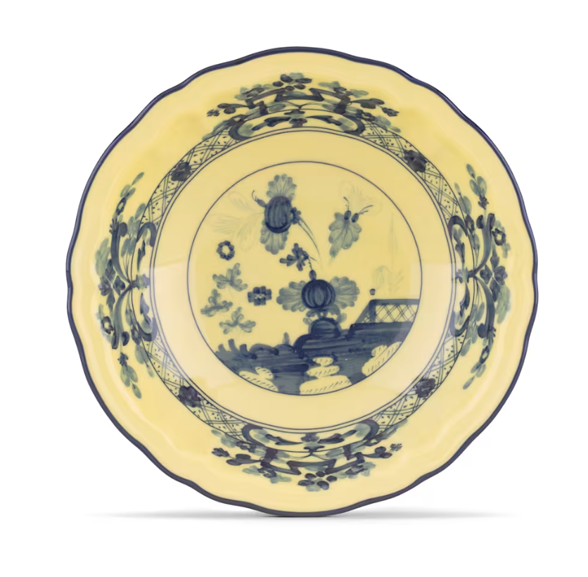 The Oriente Italiano Dinnerware Citrino by Ginori 1735 is a yellow plate with blue floral and landscape patterns, scalloped edge, and traditional chinoiserie motif inspired by classic Italian porcelain design.