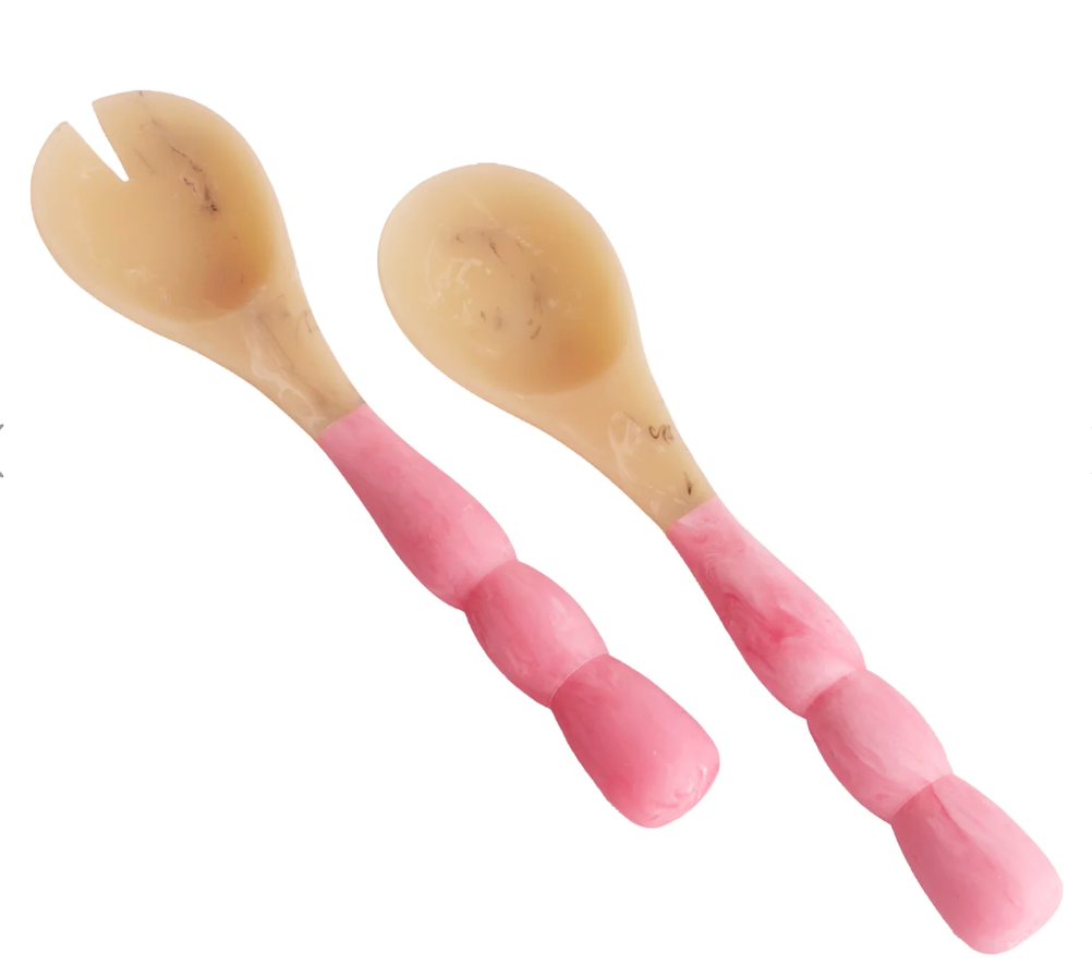 The Beatriz Ball Resin Sorbet Salad Server Set - Raspberry features two unique servers with cream-colored ends and pink handles shaped like fingers—one spoon, one fork—for standout tableware that sparks conversation.
