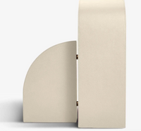 The Cubist Bookend Left - Stone Leather by Assouline, a minimalist geometric handbag with a rectangular body and curved flap in beige leather, is displayed from the side against a plain white background.