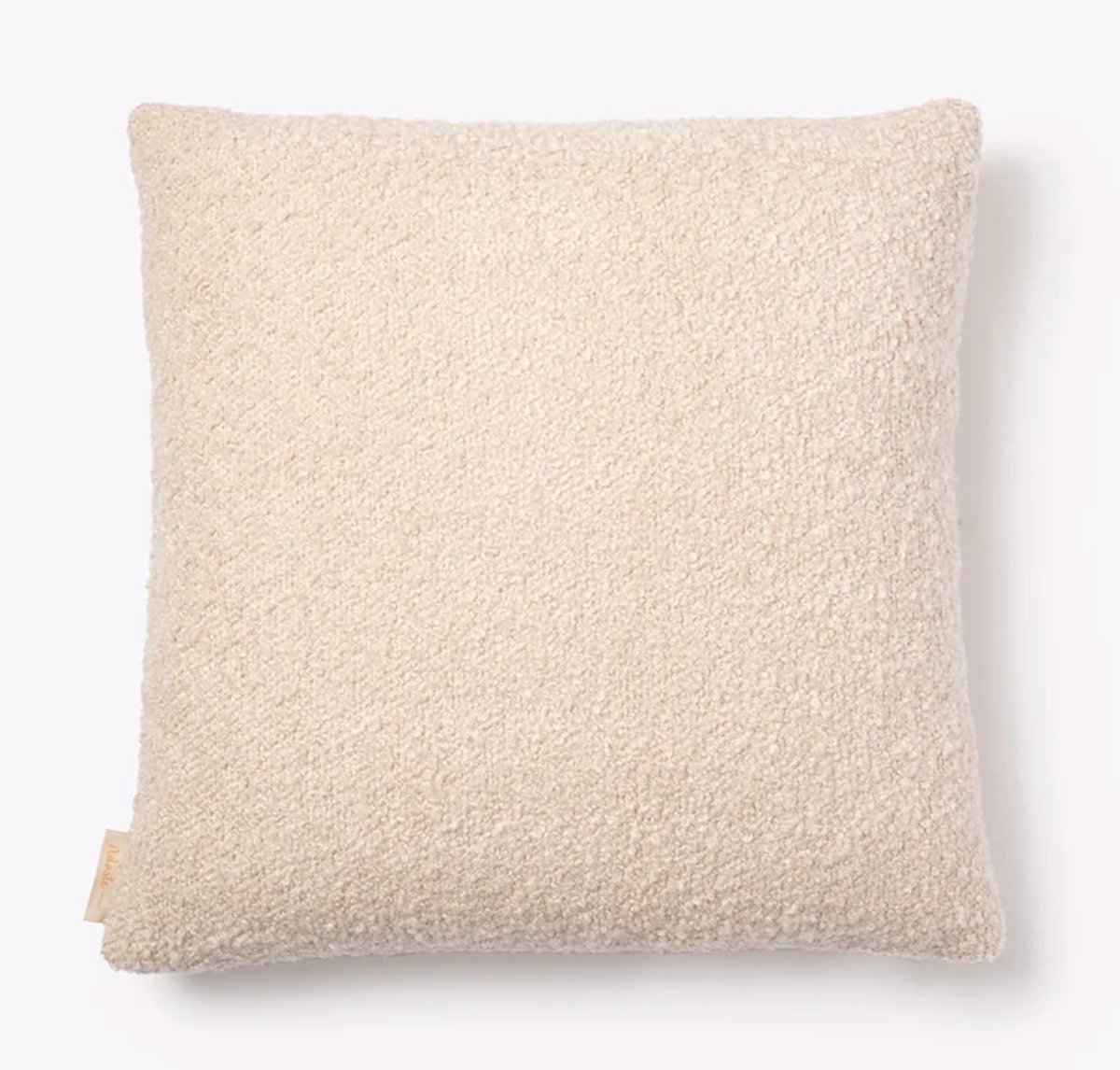 The Adaste Home Bailey Boucle Beige Pillow, featuring soft, textured boucle fabric and a small fabric tag on the bottom left edge, is displayed against a white background—an inviting decorative accent for any space.
