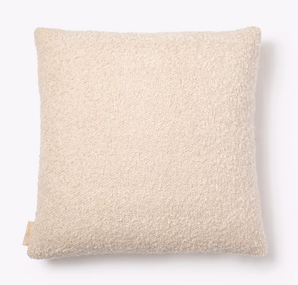 The Adaste Home Bailey Boucle Beige Pillow, featuring soft, textured boucle fabric and a small fabric tag on the bottom left edge, is displayed against a white background—an inviting decorative accent for any space.
