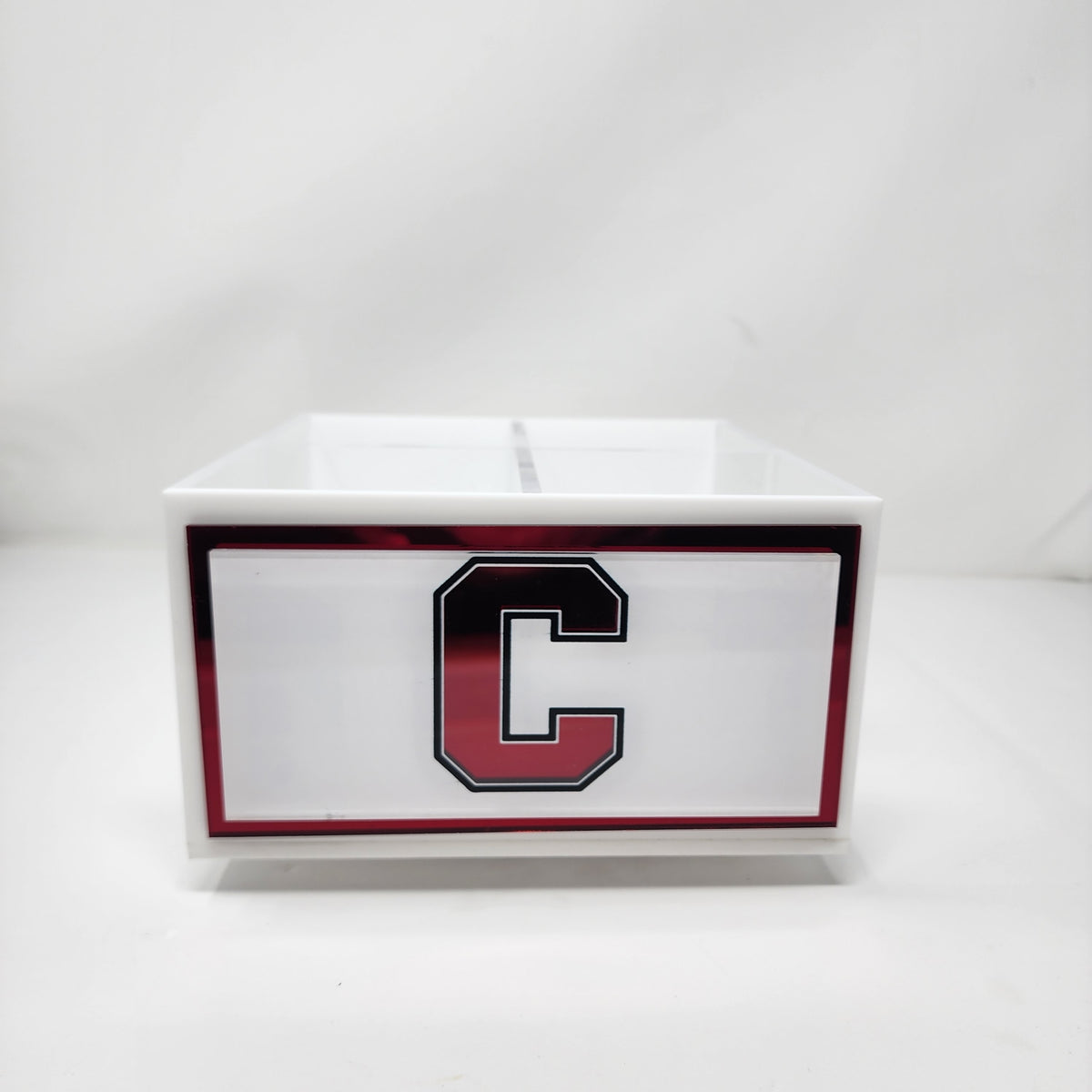The Eye Candy College Spinner, a white rectangular organizer featuring a bold black and red letter C college logo, stands out on any desk and makes a stylish organization solution.