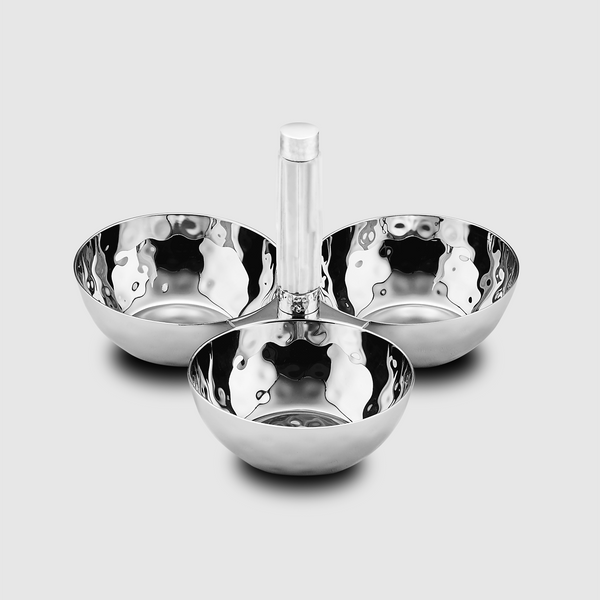 The Mary Jurek Tundra Triple Bowl With White Resin features three hammered stainless steel bowls in a clover shape, joined by a hand-carved white resin handle, displayed on a plain light gray background.