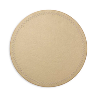 A set of four round, beige leather Starry Night Placemats by Kim Seybert, featuring subtle edge stitching and an easy-to-clean design, displayed against a white background.