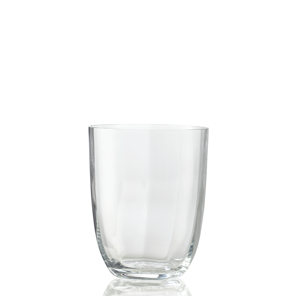 The Idra Tumbler Optic by Nason Moretti is displayed empty against a white background, with a subtle reflection beneath highlighting its clear glass design.