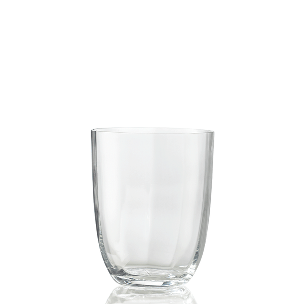 The Idra Tumbler Optic by Nason Moretti is displayed empty against a white background, with a subtle reflection beneath highlighting its clear glass design.