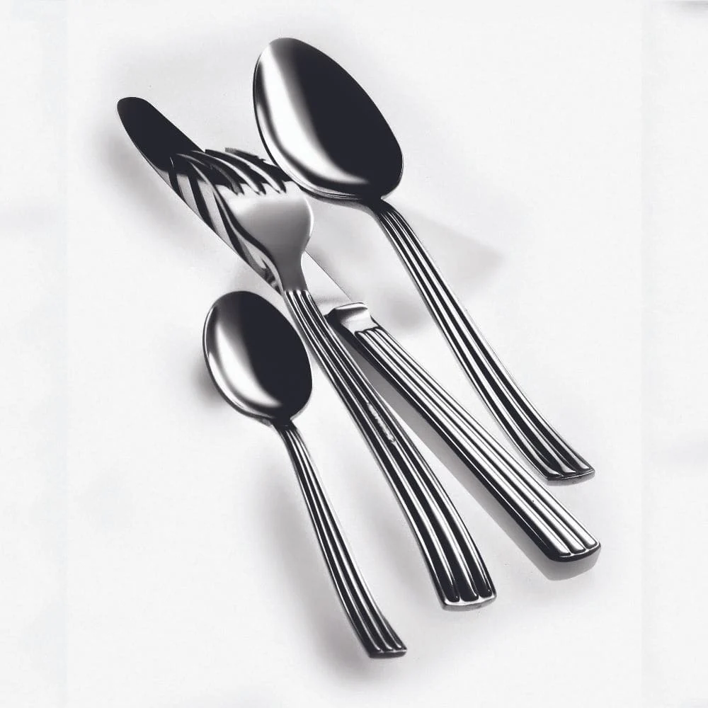 The Mepra Sole Flatware 5 Piece Setting in stainless steel, made in Italy, includes a knife, fork, large spoon, small spoon, and is displayed neatly on a white surface.