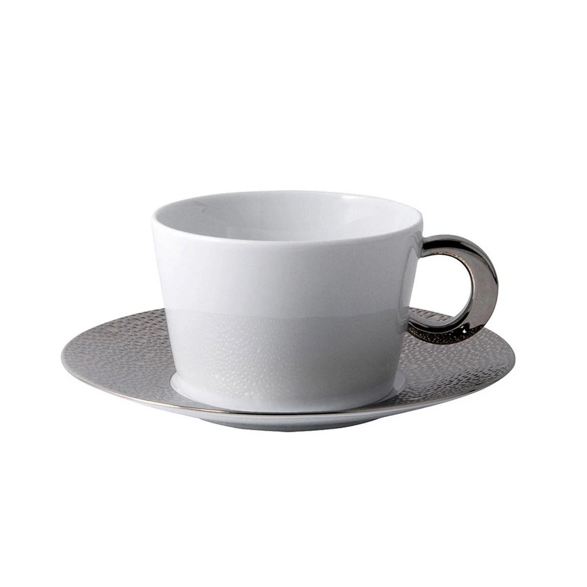 The Bernardaud Ecume Platinum teacup, featuring a white porcelain body and metallic handle, rests on a textured platinum-rimmed saucer—showcasing modern elegance from the Ecume Platinum Dinnerware collection against a white backdrop.
