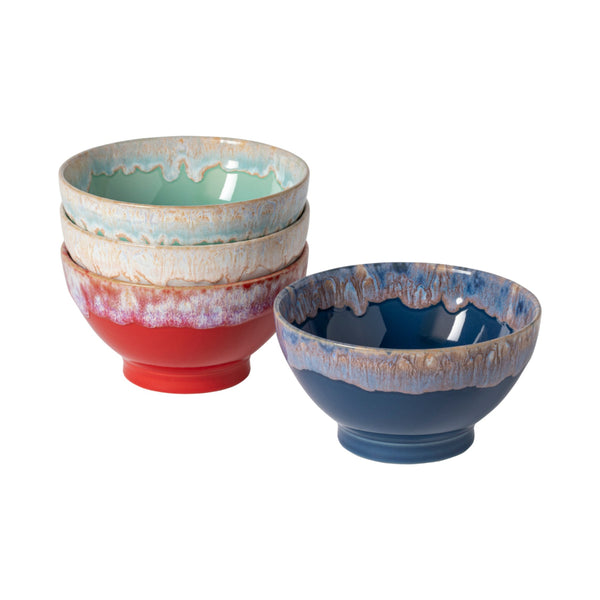 The Costa Nova Latte Bowls Set of 4 features vibrant, multicolored stoneware bowls with glazed, dripped designs and decorative rims—perfect for gifting or daily use. Three are stacked in turquoise and red; one is separate with a blue exterior.