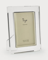 The Tizo Matte Lip Frame Clear is a sleek rectangular acrylic photo frame with a stand, featuring a placeholder insert and fitting 4 x 6 photos (10 cm x 15 cm).