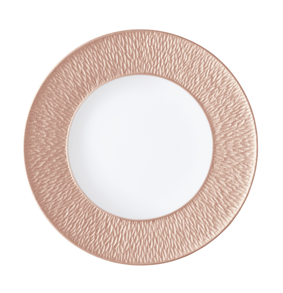 A rose gold charger plate with a textured rim, crafted to pair with Raynaud's Mineral Irise Dinnerware-Copper, sits elegantly on a white background.