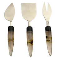 The India Handicrafts Lava Handle Cheese Knives Set includes three cheese knives with stainless steel blades and decorative resin handles, each featuring a unique blade shape for various kitchen needs, displayed vertically on a white background.