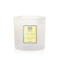A white, hexagonal candle jar with a yellow label reading "Lemon Verbena & Cedar Candle" by Antica Farmacista/Harper is displayed against a plain white background.