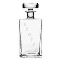 The William Yeoward Lillian Decanter Scotch is a handmade crystal glass decanter with a round stopper and “SCOTCH” etched vertically. Shown empty against a white background, this piece blends elegance and craftsmanship.