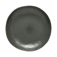 The Livia Dinnerware Matte Black plate by Casafina/Costa Nova features a round, organic-shaped edge and smooth matte finish with subtle color variations, crafted in Portugal as part of a modern collection. Shown against a white background.