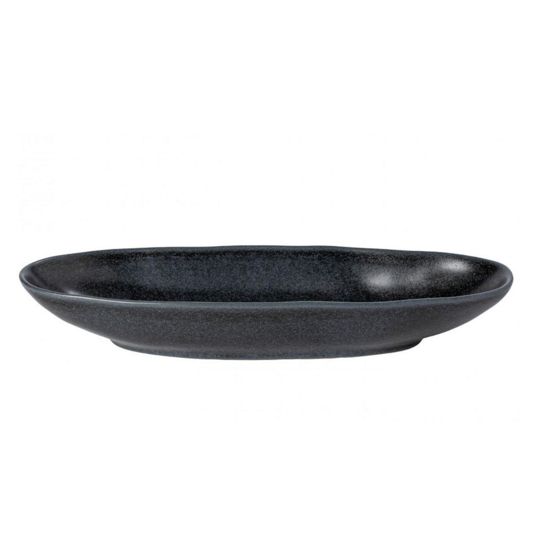 A shallow, round Livia Dinnerware Matte Black ceramic plate by Casafina/Costa Nova features a smooth, slightly textured surface as part of a modern collection, viewed from the side against a white background.